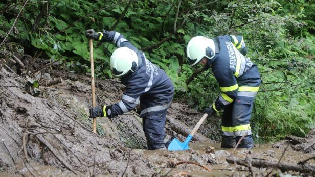 Feuerwehrleute graben im Schlamm