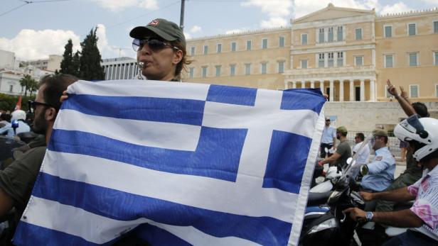 Eine Frau mit einer griechischen Flagge und einer Trillerpfeife vor dem griechischen Parlament.