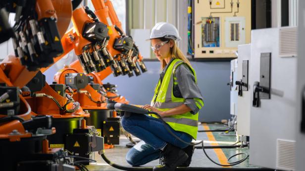 Female engineer worker working with robotic machine automation