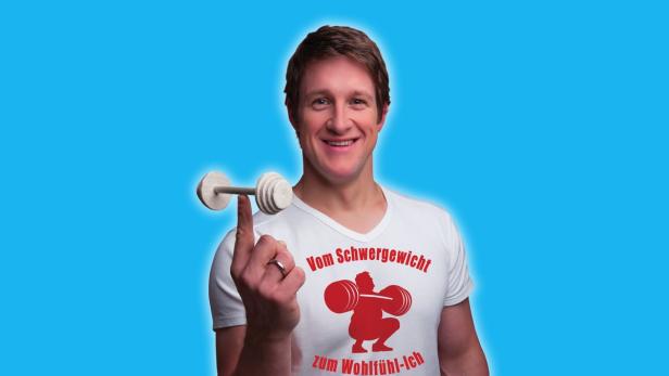 Ein lächelnder Mann balanciert eine kleine Hantel auf seinem Finger.