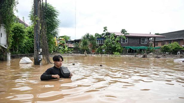 Flut in Nordthailand, Mann steht bis zur Brust im Wasser