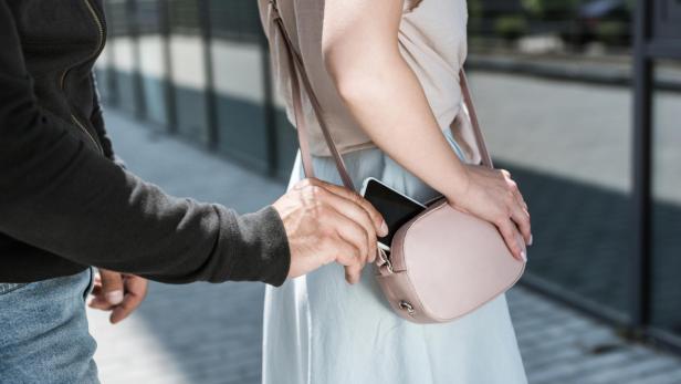 Dieb stiehlt Handy aus Tasche (Symbolbild).