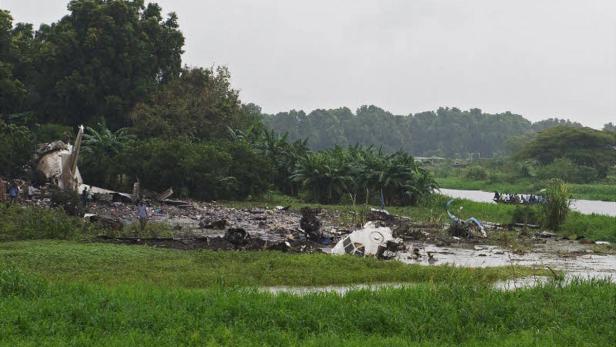 Die Trümmer eines Flugzeugs liegen in einem sumpfigen Gebiet neben einem Fluss.
