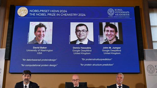 Die diesjährigen Preisträger des Chemie-Nobelpreises (links nach rechts): David Baker, Demis Hassabis und John M. Jumper, zu sehen auf einem Bildschirm während der Bekanntgabe durch die Königlich Schwedische Akademie der Wissenschaften.