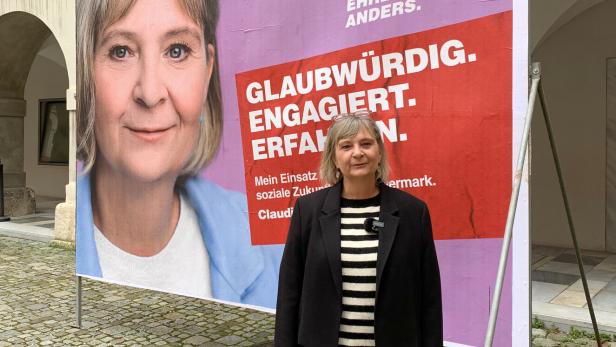 Frau vor Wahlplakat