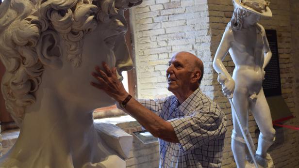 Mann greift eine große Skulptur im Museo Omero in Ancona an