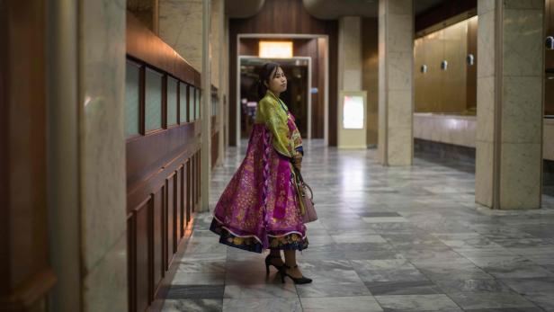 Eine Frau in traditioneller koreanischer Kleidung steht in einem Flur.