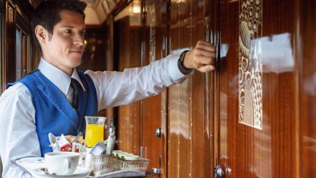 Ein Kellner serviert im Belmond Venice Simplon Orient Express Frühstück.
