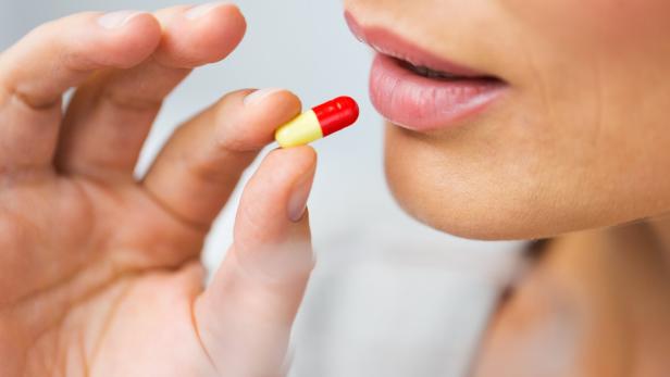 close up of woman taking medicine in pill
