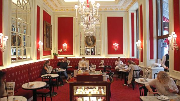 Gäste sitzen im eleganten Café Sacher in Wien.