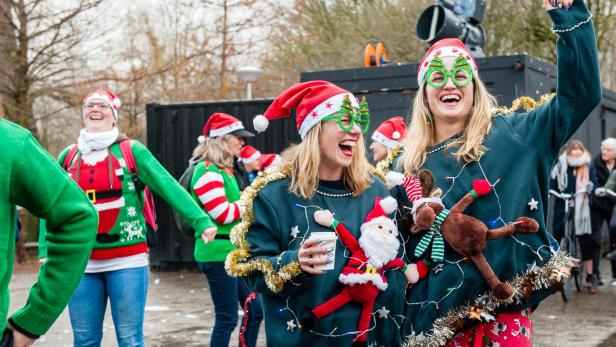 Lachende Teilnehmer beim Ugly Christmas Sweater Run in Amsterdam