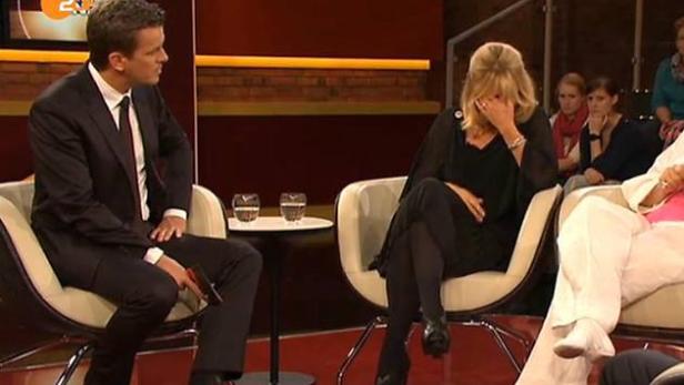 In einer Talkshow sitzt ein Mann im Anzug neben einer weinenden Frau.