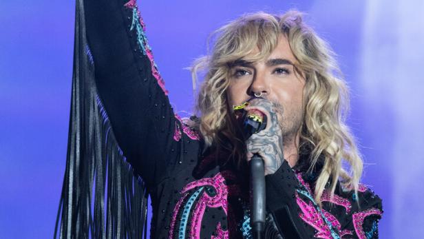 Bill Kaulitz tritt in einer verzierten Jacke mit Fransen auf.