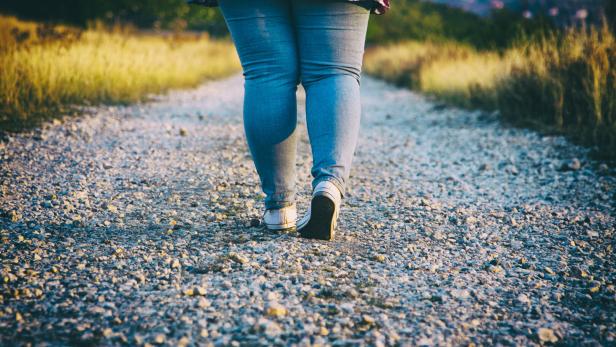 Junge Frau geht auf Landstraße.