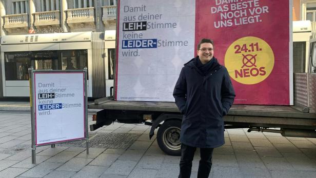 Mann vor Wahlplakat