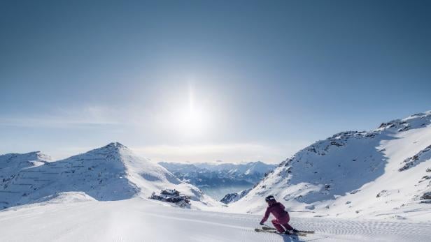 Ein Skifahrer in einer schneebedeckten Berglandschaft.