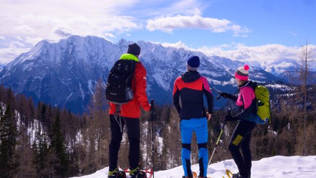 Drei Schneeschuhwanderer im Schnee vor Grimming