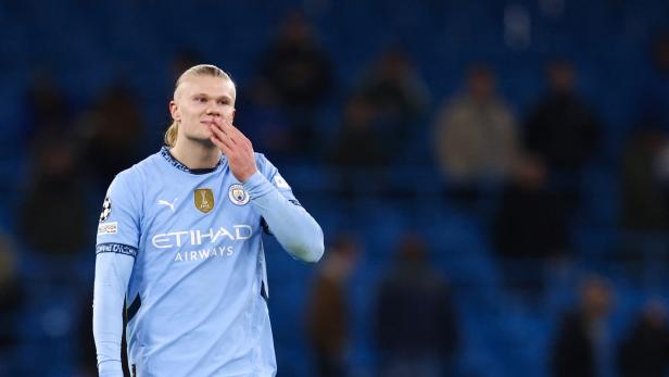 Erling Haaland im hellblauen Trikot von Manchester City hält sich die Hand vor den Mund.