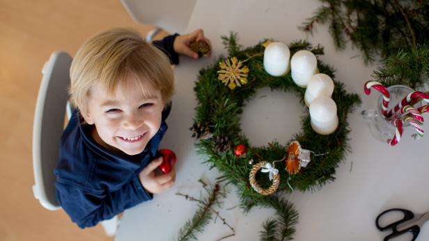 Ein Kind beim Adventkranz.