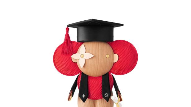 Eine Louis Vuitton Holzfigur in Form eines Absolventen mit Doktorhut und Diplom.
