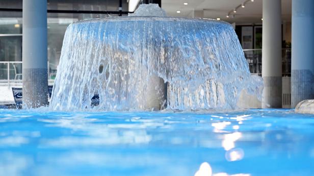 Ein Wasserfall ergießt sich in ein blaues Becken.