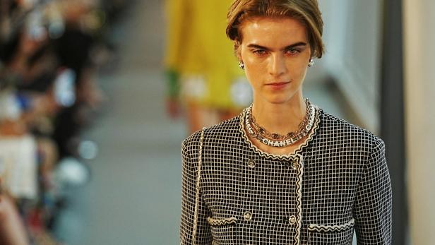 Ein Model auf dem Laufsteg trägt eine Jacke und eine Halskette von Chanel.