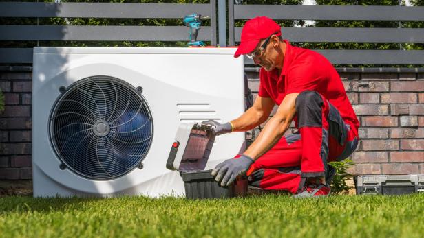 Bildnummer 1693727544 Professional Caucasian Heat Pumps Technician in His 40s Installing New Residential Modern Heating Device. HVAC Industry Theme.