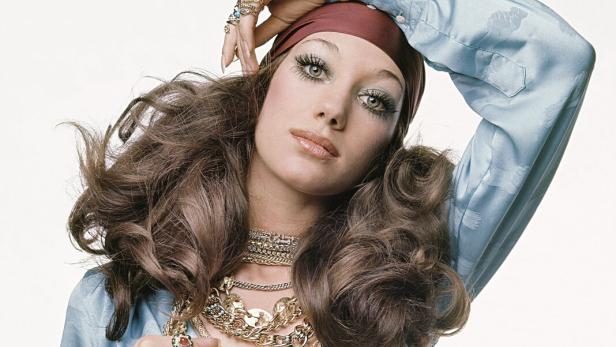 Ein Model in den Sechzigerjahren mit langen Haaren und unzähligen Ketten und Ringen.