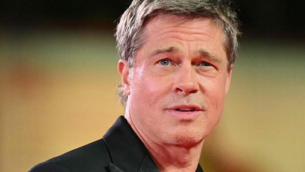 Brad Pitt in einem schwarzen Anzug auf einem roten Teppich.