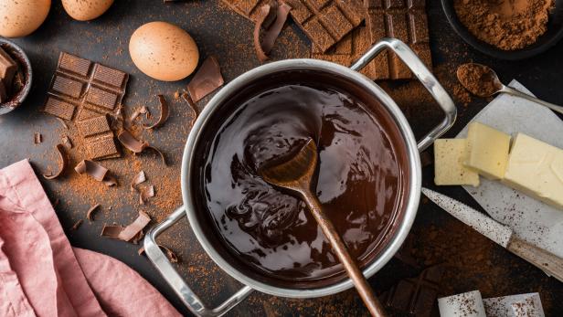 geschmolzene Schokolade im Topf mit Zutaten wie Butter und Eiern