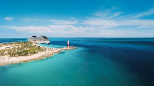 Kristallblaues Meerwasser mit einem Leuchtturm und einem Kreuzfahrtschiff im Hintergrund