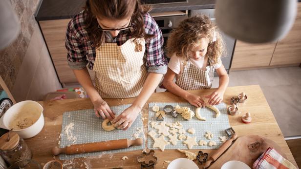 Mutter und Tochter bereiten Teig in der Küche zu.