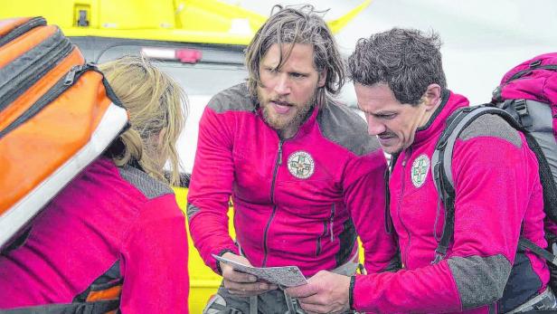 Die Bergretter Katharina (Luise Bähr, l.), Markus (Sebastian Ströbel, M.) und Tobias (Markus Brandl, r.) stimmen die koordinierte Suche nach zwei Vermissten ab.