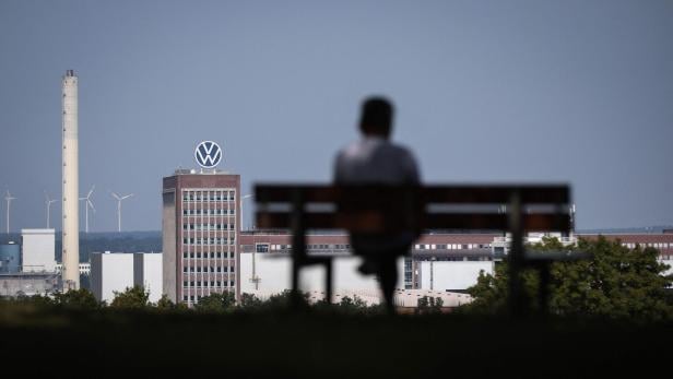 Spaziergänger auf Parkbank vor VW-Zentrale