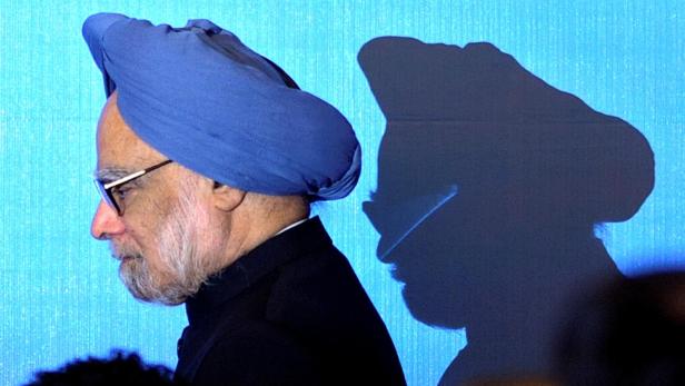 FILE PHOTO: India's Prime Minister Manmohan Singh walks on stage for a photo opportunity as part of the 5th East Asia Summit in Hanoi