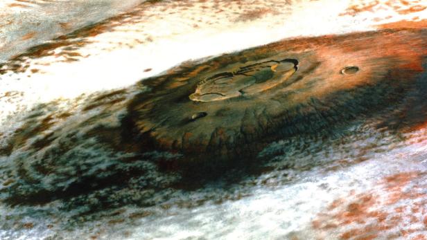 Ein großer Krater erhebt sich aus einer Wolkenmasse