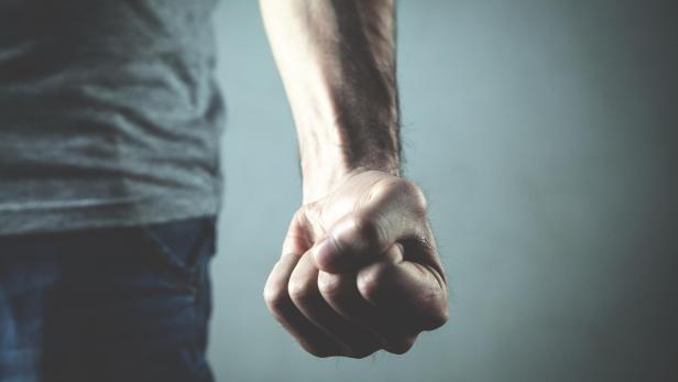 Caucasian angry and aggressive man threatening with fist.