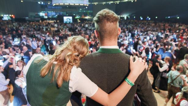 Mann und Frau in Tracht sehen auf Ballgäste