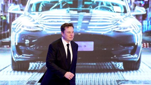 Elon Musk vor Bild eines Tesla Model 3