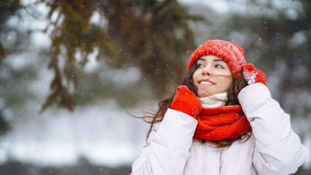 Frau mit Schal und Mantel beim winterlichen Spaziergang