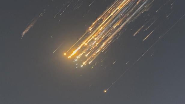 Orangefarbene Lichtkugeln fliegen über den Himmel, Trümmer einer SpaceX-Rakete über Turks- und Caicosinseln.