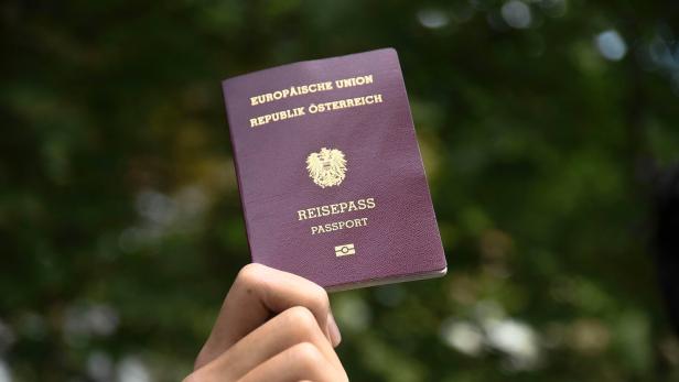 Eine Hand hält einen österreichischen Reisepass.