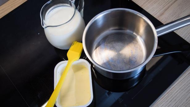 Butter am Rand eines Kochtopfs soll das Überkochen von Milch verhindern