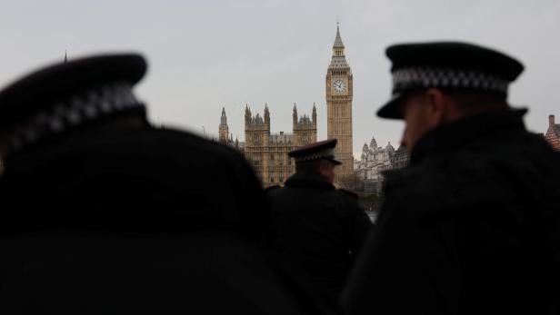Polizisten stehen mit dem Elizabeth Tower, allgemein bekannt als Big Ben, und den Houses of Parliament im Hintergrund in London.
