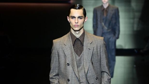 Ein Mann in einem karierten Anzug auf einem Laufsteg.