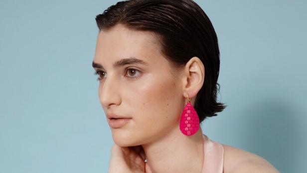 Eine Frau mit einem pinkfarbenen Ohrring aus dem 3D-Drucker.