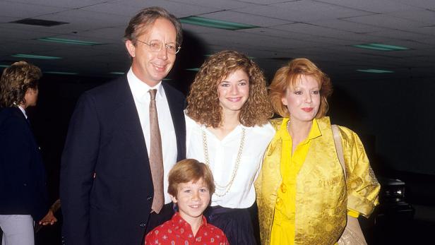 Eine Familie posiert für ein Foto in einem Innenraum. Eine Familie posiert für ein Foto in einem Innenraum.