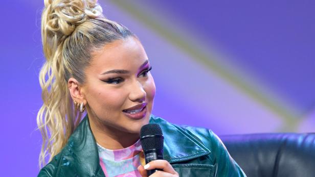 Shirin David hält ein Mikrofon in der Hand.