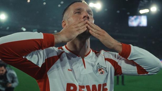 Lukas Podolski in einem Trikot des 1. FC Köln schickt Küsse in die Menge.