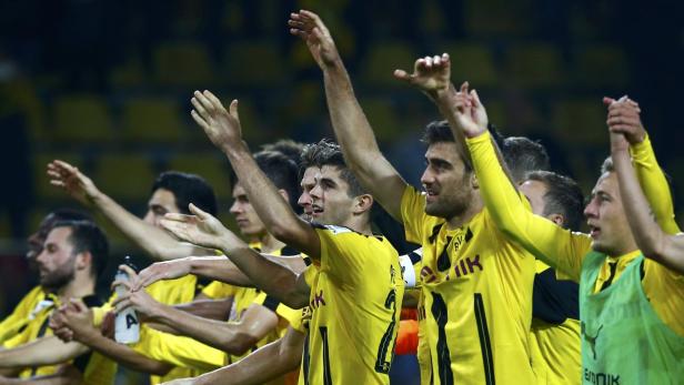 Eine Gruppe von Fußballspielern von Borussia Dortmund jubelt mit erhobenen Armen.